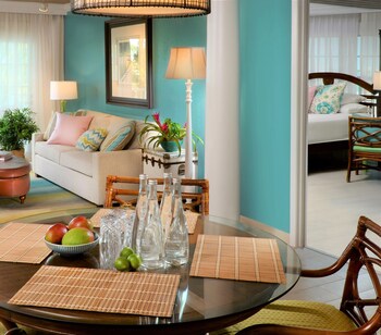 A balcony with a table set for breakfast, overlooking the sea. at Ocean Key Resort - A Noble House Resort