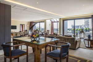 Um saguão de hotel moderno com mesa de bilhar, assentos confortáveis e uma grande janela com vista para a cidade.