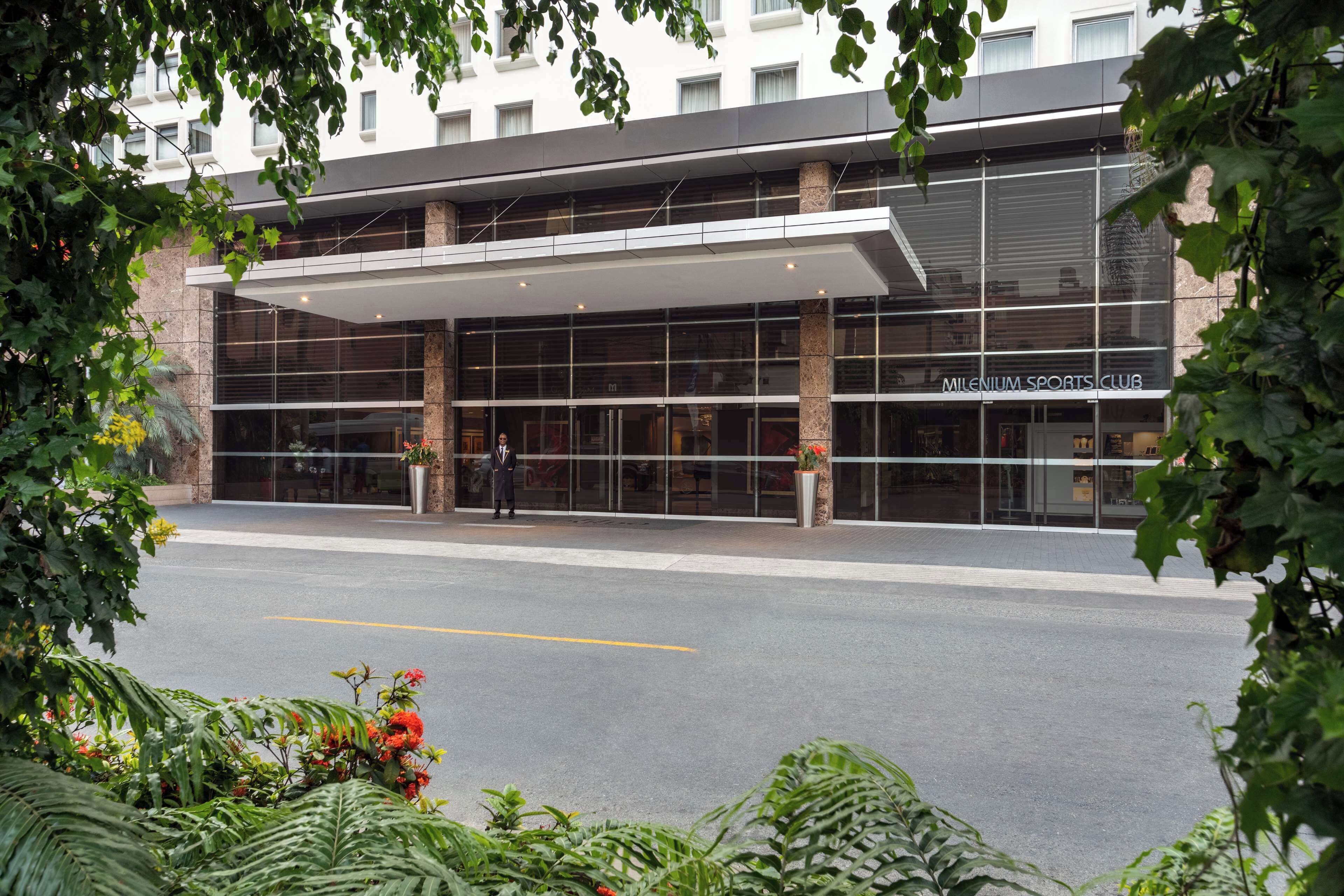 A modern building with a glass facade and a covered entrance.