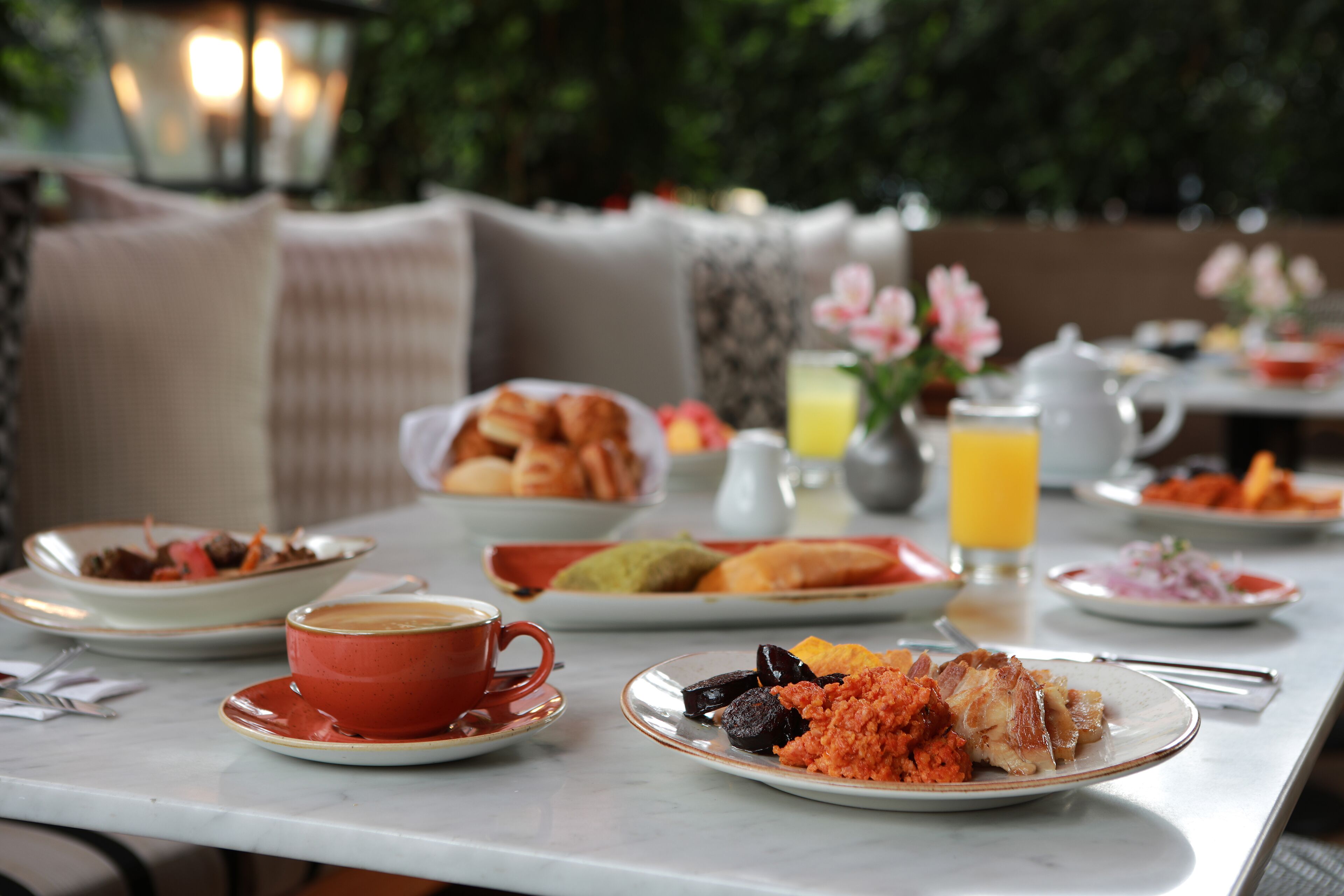 A dining table with various dishes, a coffee cup, and a pitcher of orange juice.