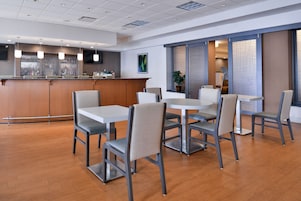 Un comedor moderno con barra, suelo de madera y muebles contemporáneos.