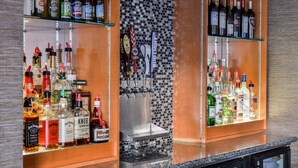 A bar area with shelves of liquor bottles and a tap system. - Holiday Inn Hotel & Suites Rochester - Marketplace by IHG (Rochester)