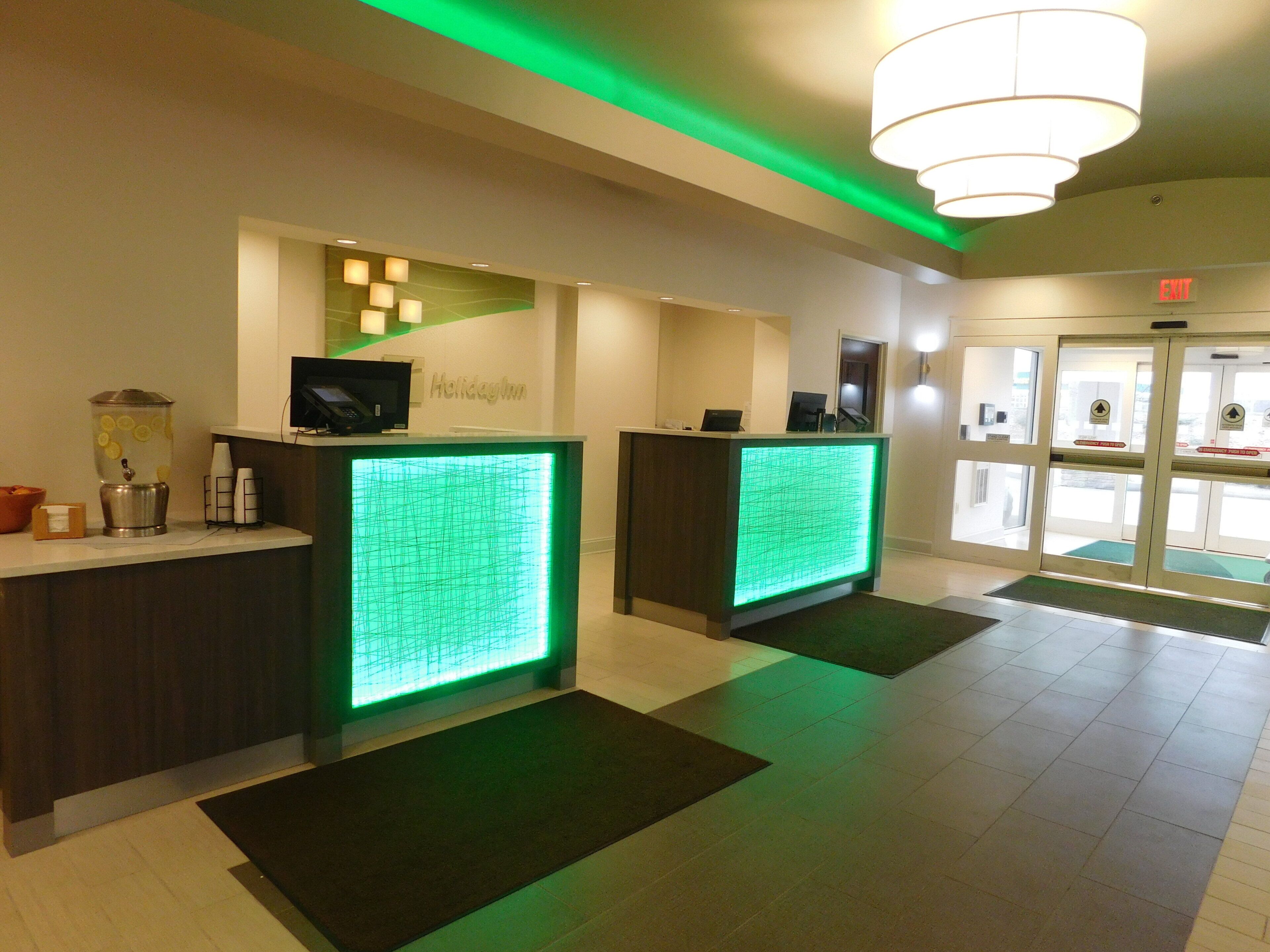 A reception area with two reception desks, a water dispenser, and a digital display.