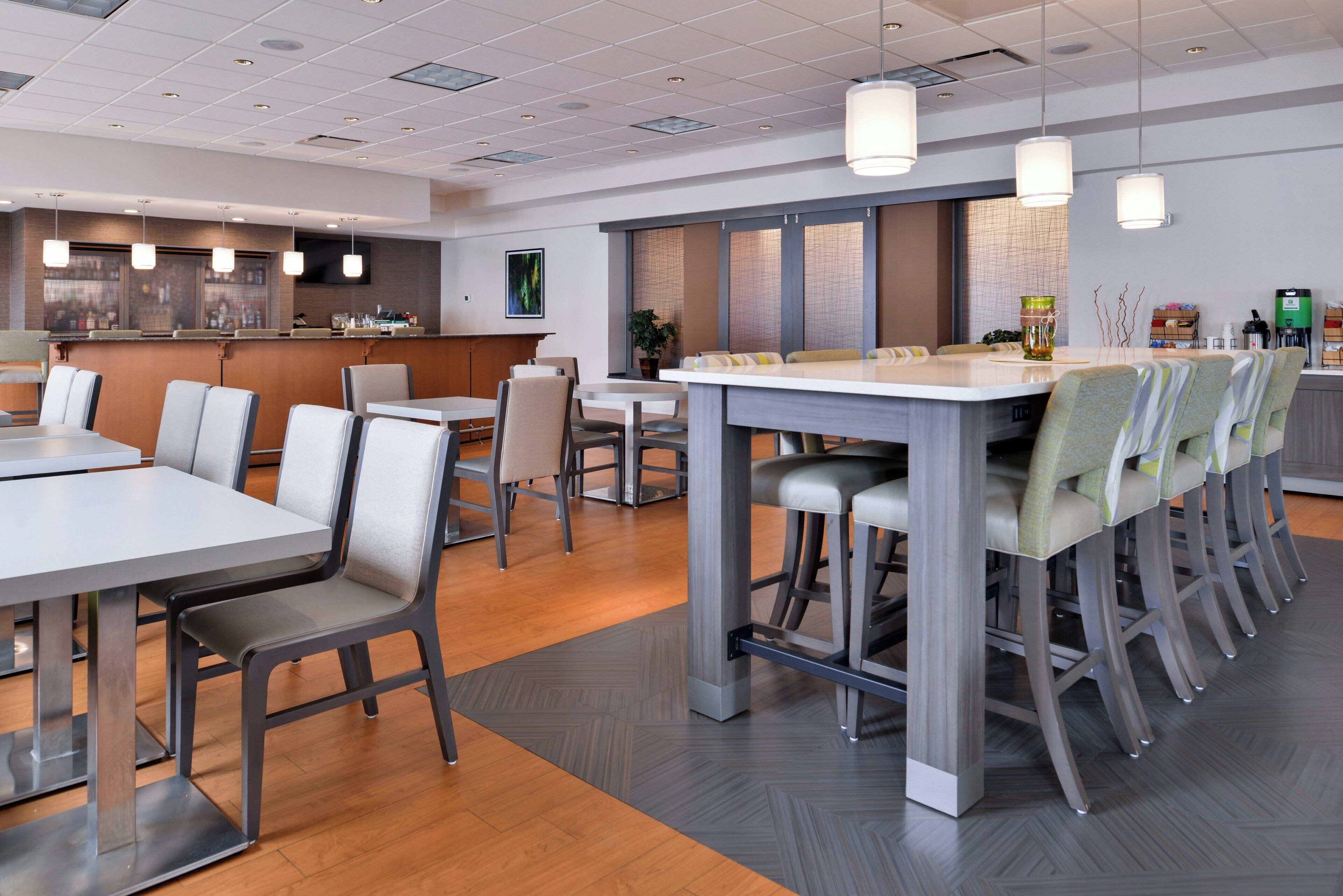 A modern dining area with a long communal table and individual seating.