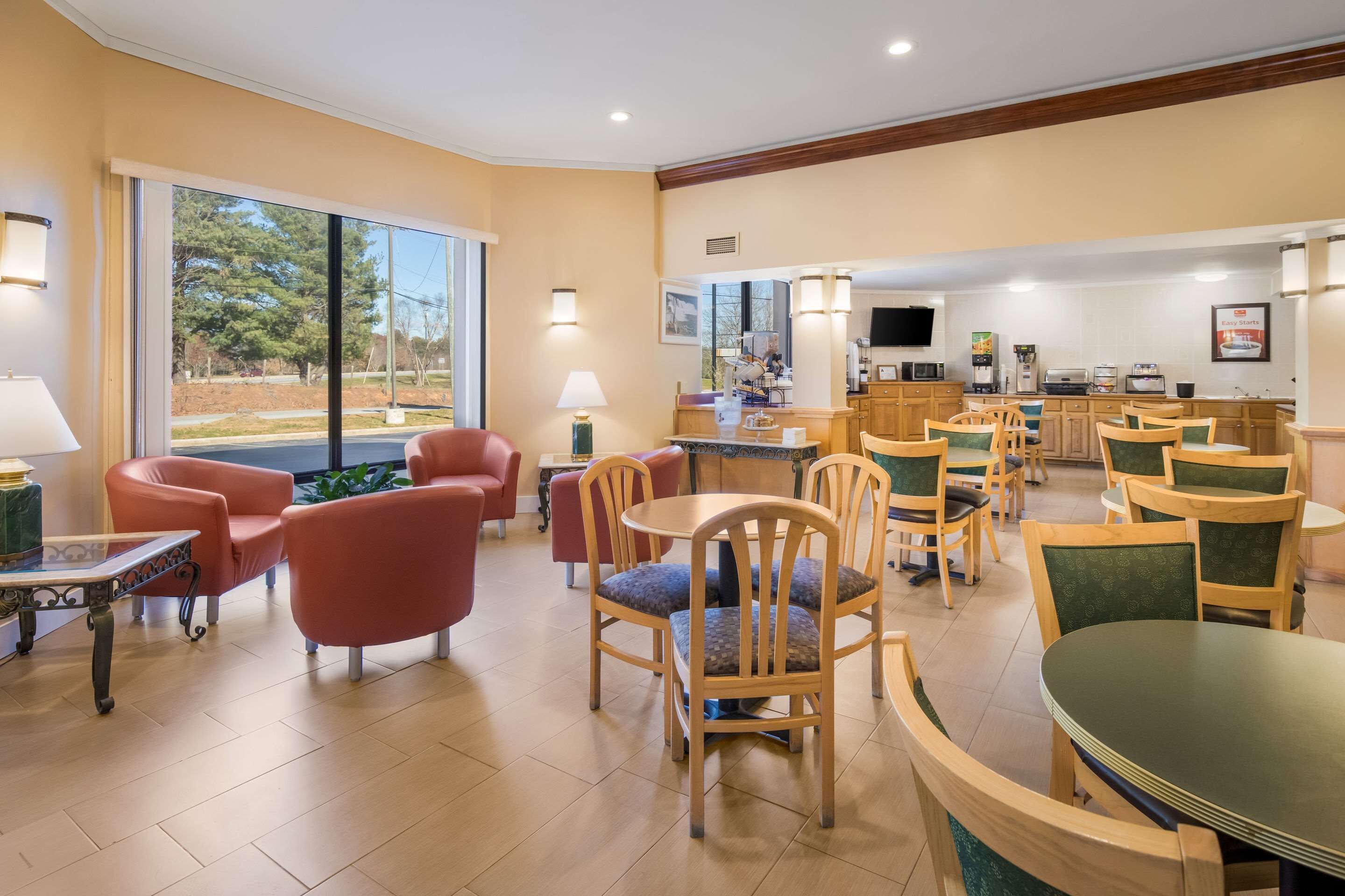 Un hall de hotel con un ventanal grande, zona de estar y kitchenette.