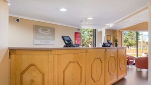 A reception desk with a digital kiosk, a framed logo, and a hotel policy sign. - Econo Lodge Hendersonville (Hendersonville)