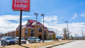 A hotel named Econo Lodge with a red sign, a parking lot with several cars, and a clear blue sky. - Econo Lodge Hendersonville (Hendersonville)