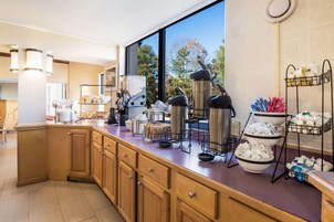 Una cocina moderna con armarios de madera, encimera de mármol y diversos electrodomésticos.