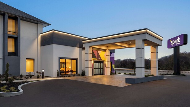 A modern hotel entrance with a covered walkway, large windows, and a 'Spark' sign. - Spark by Hilton Nashville at Opryland (Nashville)