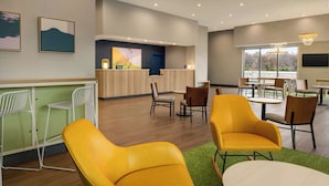 A modern hotel lobby with a reception desk, seating area, and large windows offering a view. - Spark by Hilton Nashville at Opryland (Nashville)