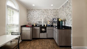 A kitchen with a wooden countertop, a built-in oven, and a window with blinds. - Days Inn by Wyndham Canton (Canton)