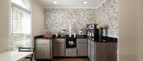 A kitchen with a wooden countertop, a built-in oven, and a window with blinds.