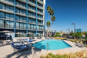 A hotel with a swimming pool, sun loungers, and palm trees. - Holiday Inn Express & Suites Santa Ana - Orange County by IHG (Santa Ana)
