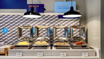 Aamiainen tarjoillaan buffetpöydästä, ja ruokalajeissa on selkeät kyltit. Tarjolla on muun muassa munakokkelia, munakokkelia, jossa on pelkkiä valkuaisia ja kasviksia, kalkkunamakkaraa ja pekonia.