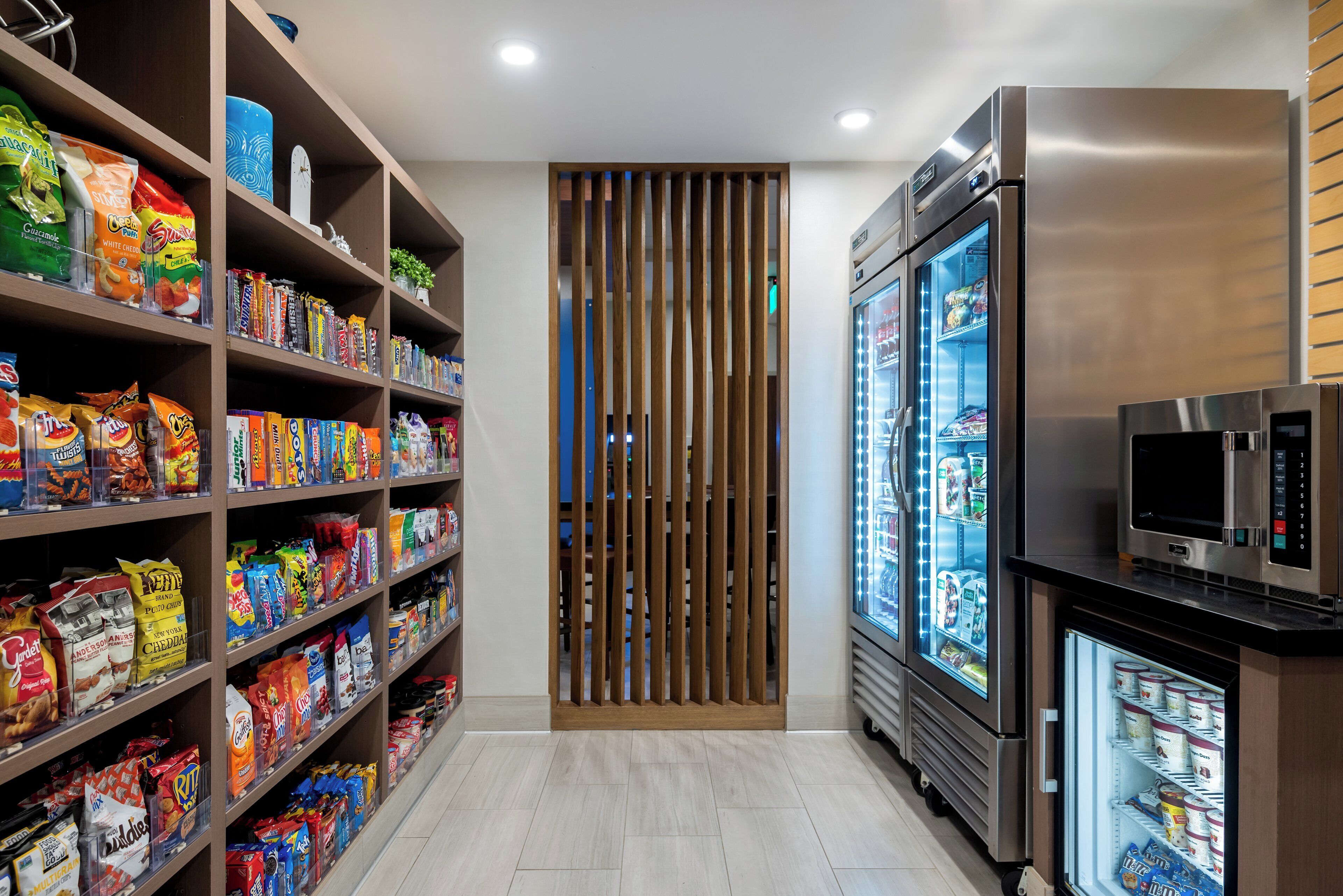 A snack aisle with various packaged goods and a refrigerated display.