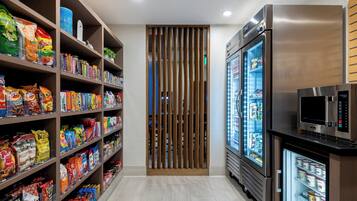 A snack aisle with various packaged goods and a refrigerated display.