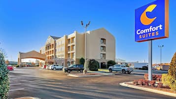 A Comfort Suites hotel with a large sign, a parking lot, and a building with multiple floors.