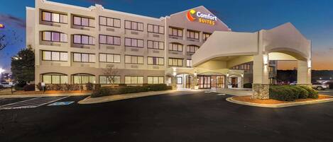 A Comfort Suites hotel with a modern design, featuring a large entrance and a parking lot.