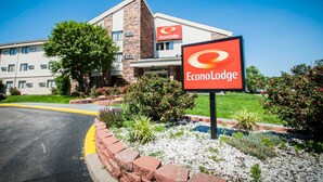 A hotel with a prominent EconoLodge sign, a brick facade, and a landscaped garden area.