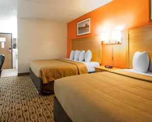 A hotel room with two beds, a headboard with a clock, a framed picture on the wall, and a carpeted floor. - Econo Lodge Kansas City Downtown North (North Kansas City)