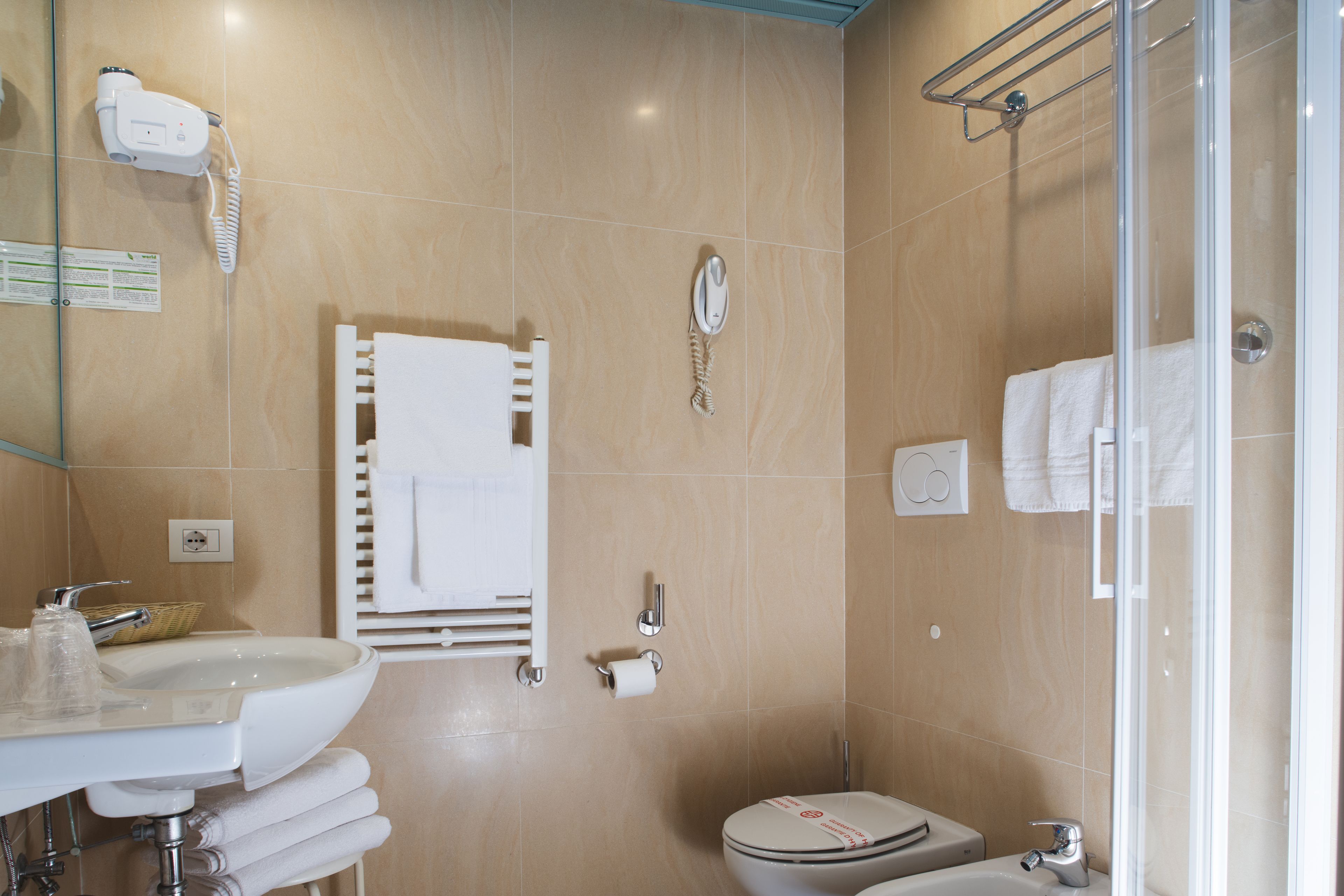 Un baño moderno con lavamanos, inodoro y ducha.