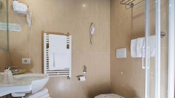 Un baño moderno con lavamanos, inodoro y ducha.