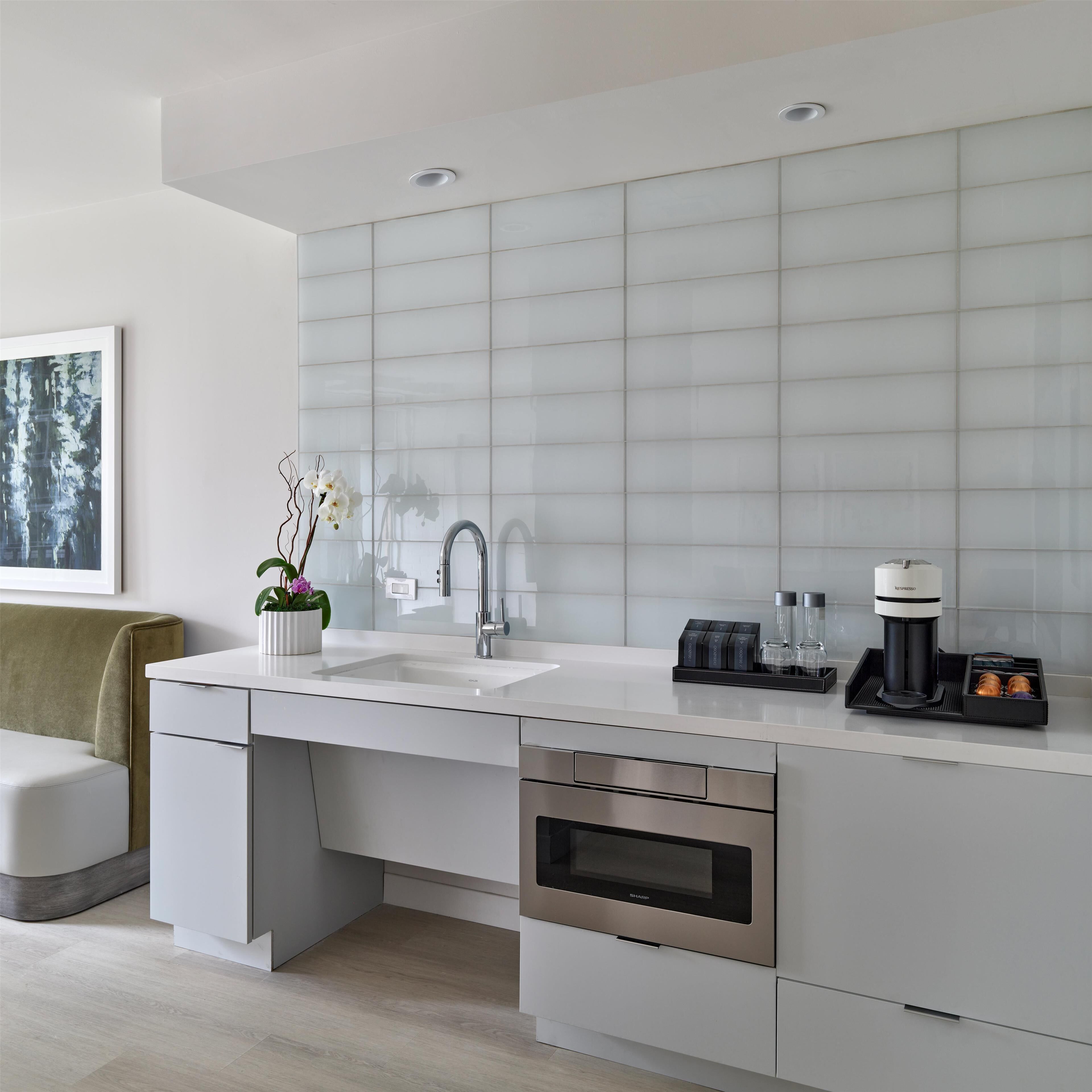 A modern kitchen with a built-in sink, stainless steel appliances, and a coffee maker.