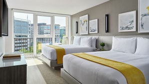 A modern hotel room with two beds, a large window with a city view, a flat-screen TV, and artwork on the wall. - One Washington Circle DC, Tapestry Collection by Hilton (Washington)