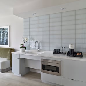 A modern kitchen with a white countertop, stainless steel appliances, and a built-in oven. - One Washington Circle DC, Tapestry Collection by Hilton (Washington)