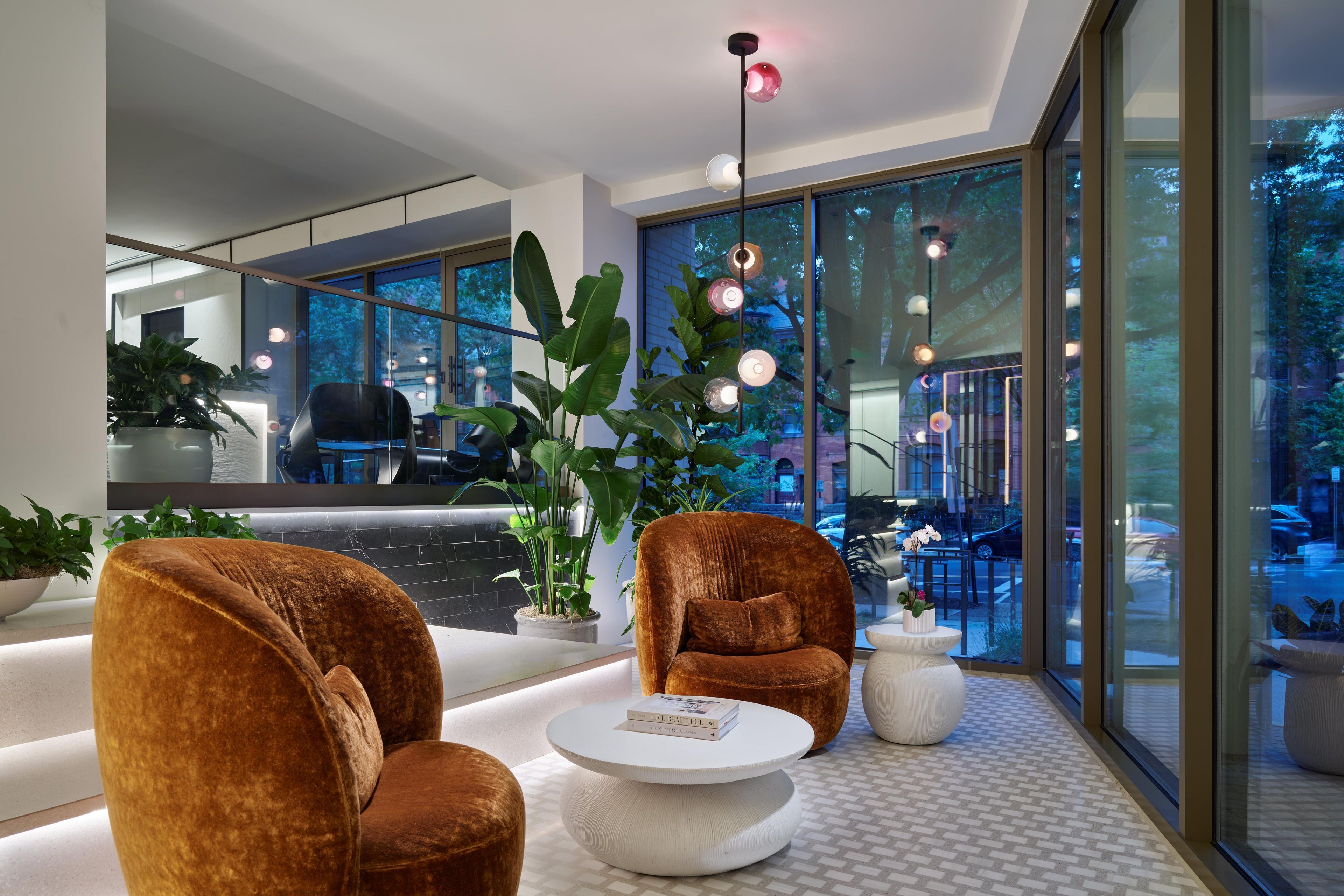 A modern interior with a seating area, a coffee table, and large windows.