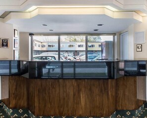 A reception desk with a view of parked cars and buildings outside. - Econo Lodge Downtown Ottawa (Ottawa)