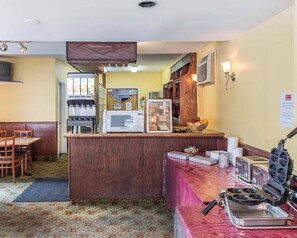 A hotel room with a kitchenette, a dining area, and a bathroom visible through the doorway. - Econo Lodge Downtown Ottawa (Ottawa)