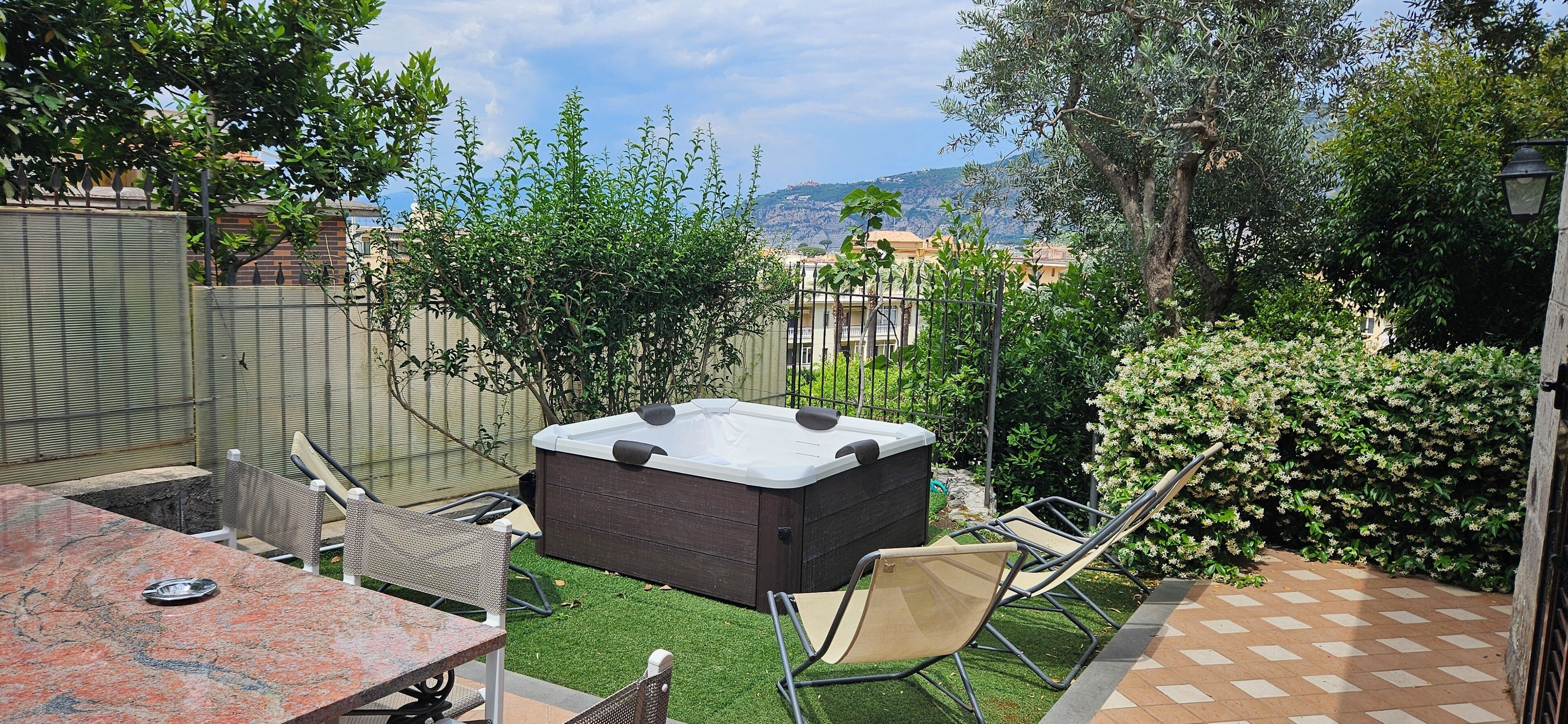 Un patio trasero con un jacuzzi, una mesa y sillas.