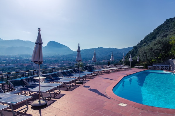 Piscine extérieure, parasols de plage, chaises longues