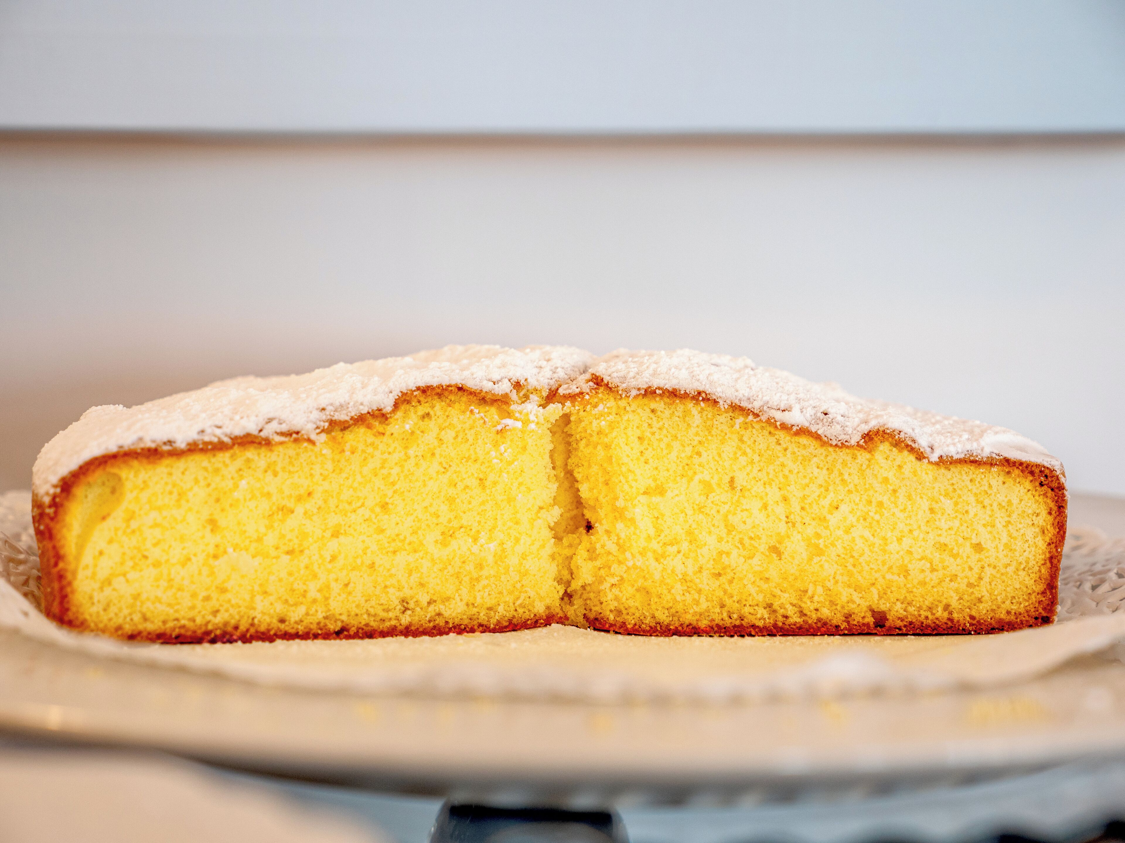 Ein Stück Kuchen mit Puderzucker, auf einem Teller serviert.