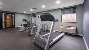 Kuntosali, jossa on juoksumattoja, kuntopyörä ja crosstrainer.