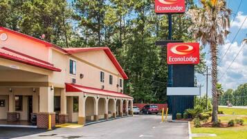 Un EconoLodge à deux étages, avec un toit rouge et des murs de couleur beige, comprenant un parking et offrant une vue sur un ciel dégagé.