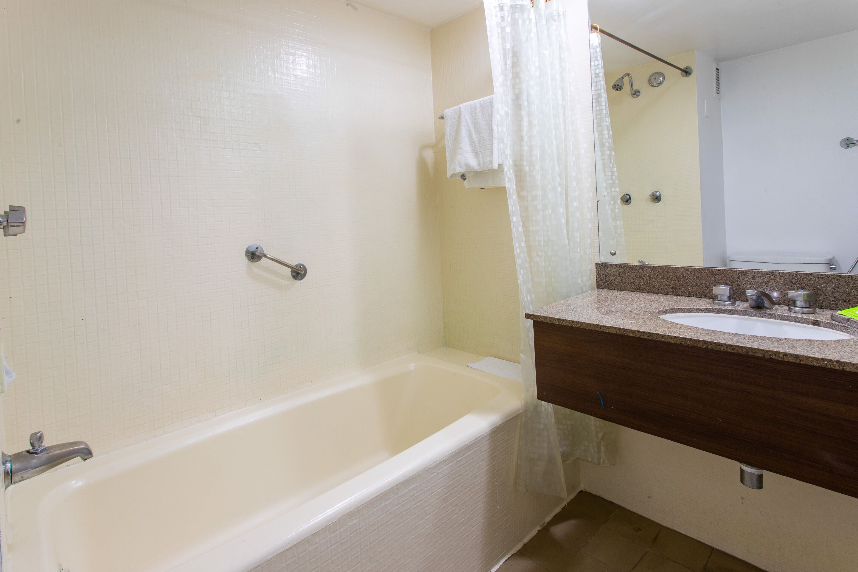 Une salle de bain avec une baignoire, un lavabo et un miroir.