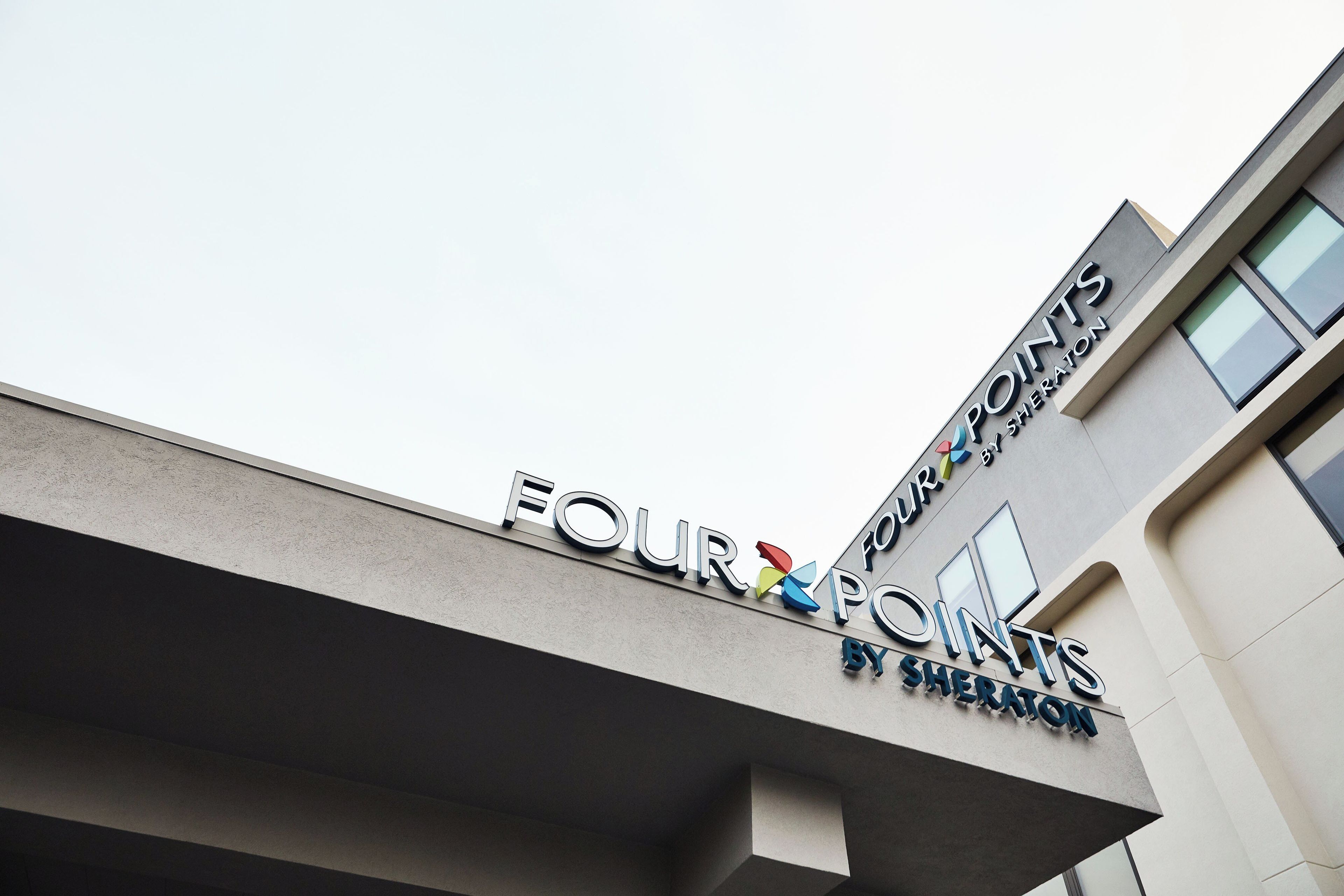 A building with a sign that reads 'FOUR POINTS BY SHERATON'.
