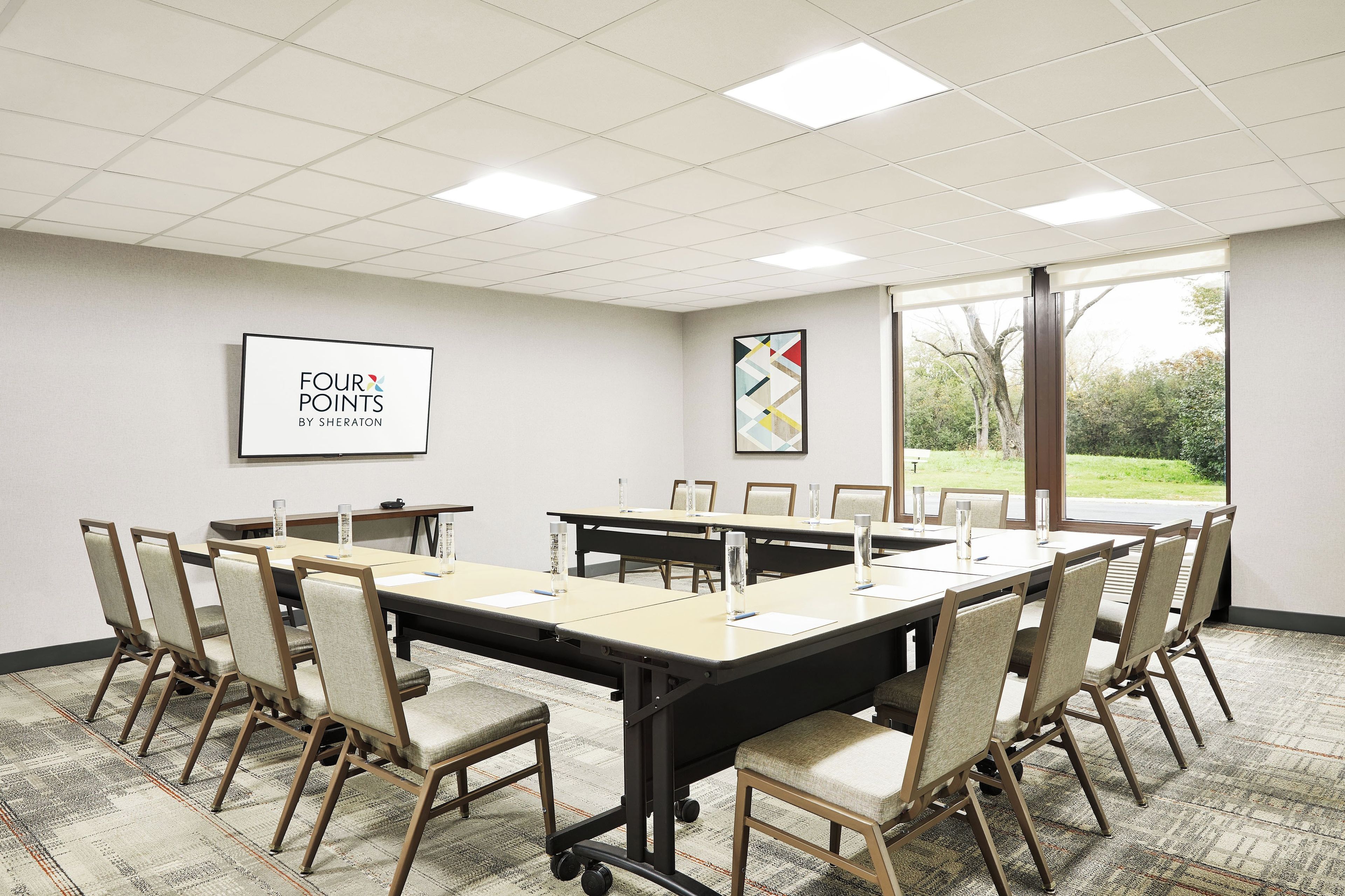A conference room with a long table, chairs, and a large window.