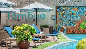 A poolside area with lounge chairs, umbrellas, and a mural. - Nairobi Safari Club by Swiss-Belhotel (Nairobi)