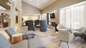 Amplia sala de estar con muebles modernos, chimenea y ventanas grandes.