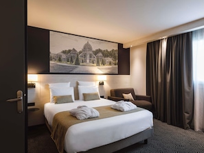 A hotel room with a large bed, two bedside tables, a chair, a painting on the wall, and a window with curtains. - Mercure Lyon Centre Charpennes Parc de la Tete d'Or (Villeurbanne)