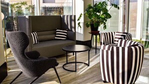 A modern lounge area with a sofa, armchairs, a small table, and a potted plant. - Mercure Lyon Centre Charpennes Parc de la Tete d'Or (Villeurbanne)