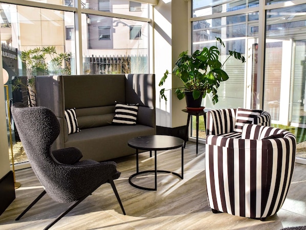 A modern lounge area with a sofa, armchairs, a small table, and a potted plant. - Mercure Lyon Centre Charpennes Parc de la Tete d'Or (Villeurbanne)