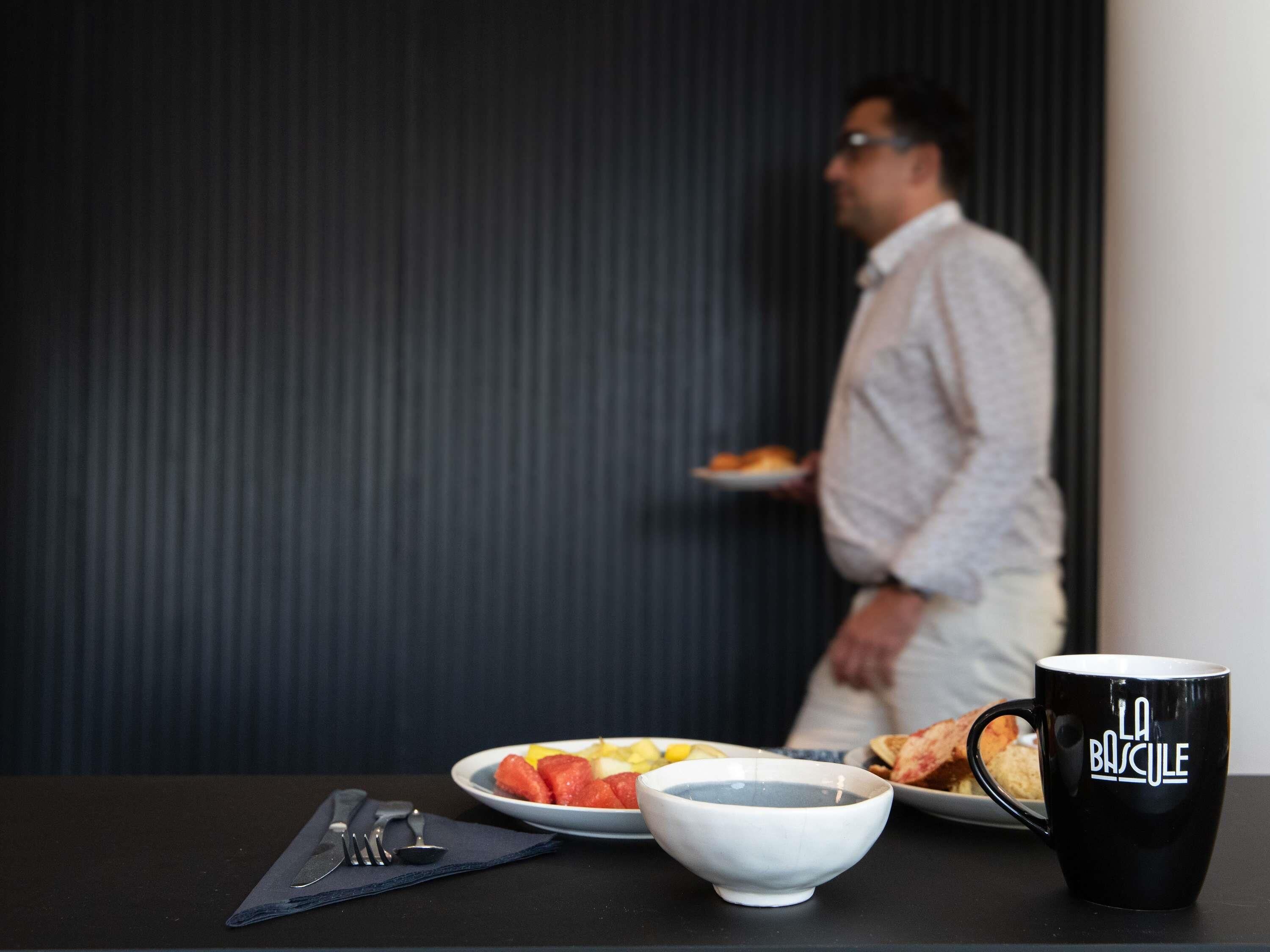 A table with a bowl, a plate with food, a mug, and cutlery.