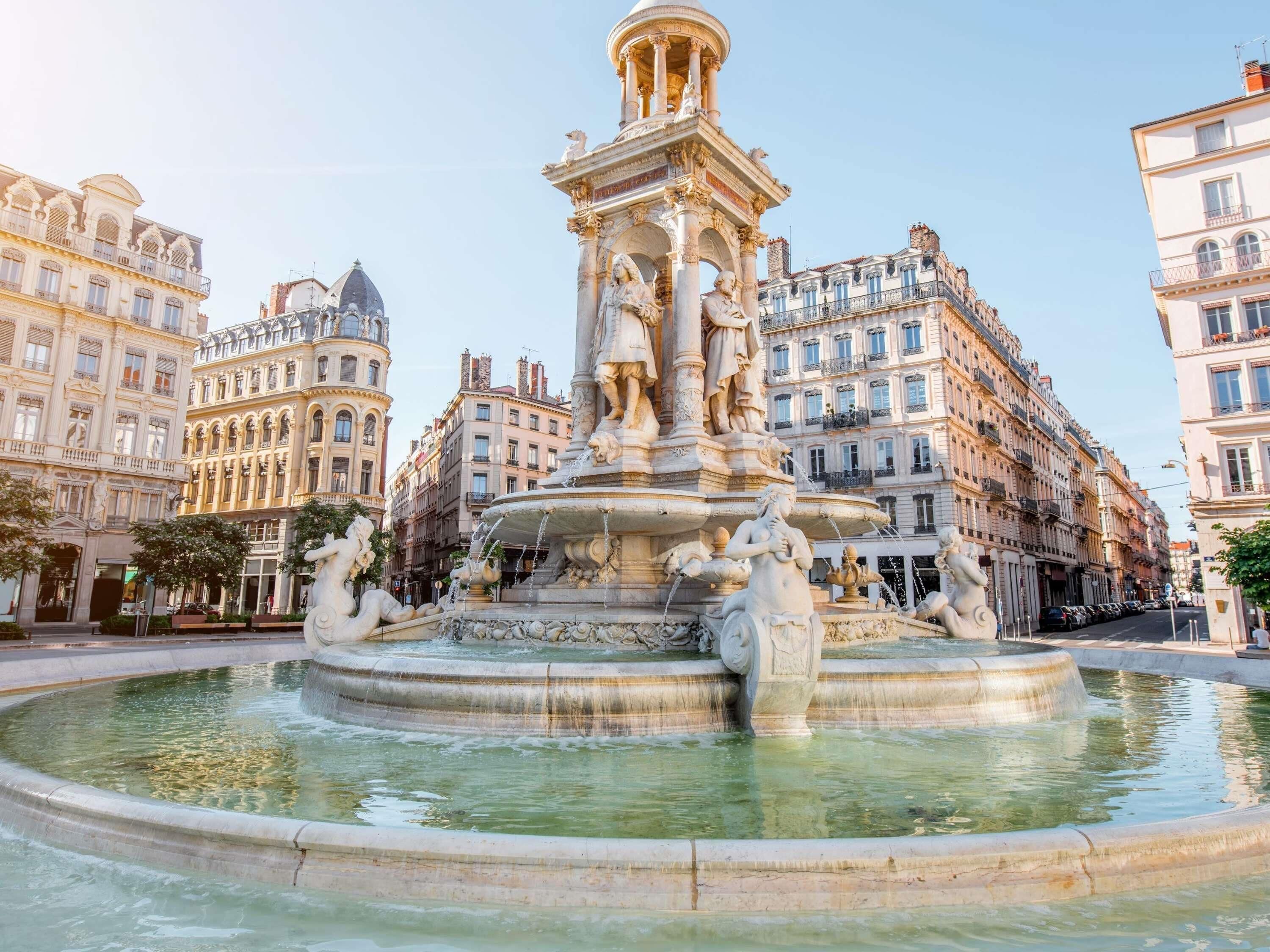 A historic fountain with statues, surrounded by classical architecture.