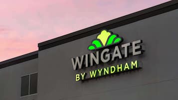 Un edificio con un letrero que dice "WINGATE BY WYNDHAM" y un logotipo estilizado encima del texto.
