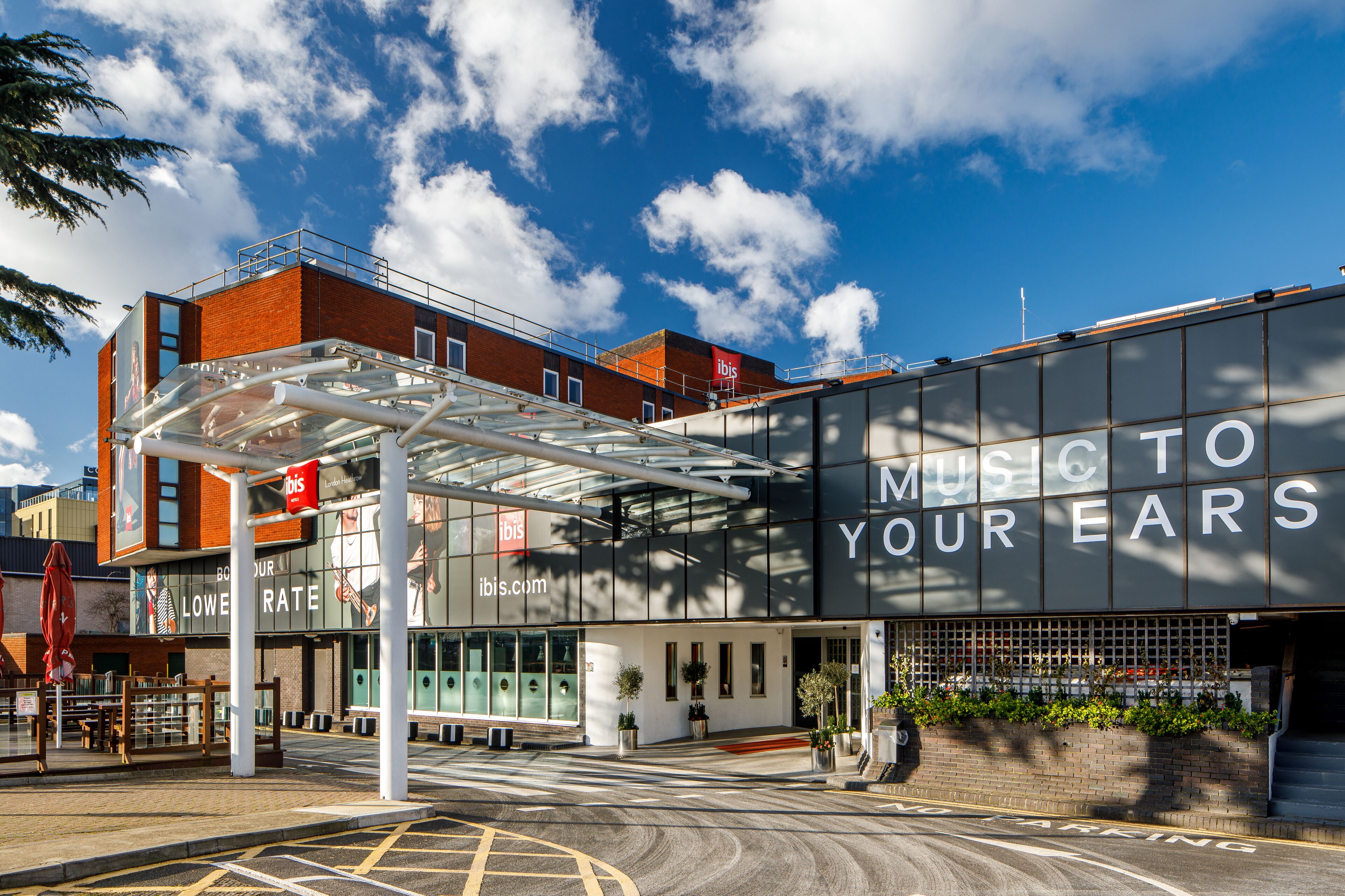 Un bâtiment moderne avec une grande enseigne sur laquelle on peut lire : « UNE MUSIQUE QUI VOUS RAVIRA ».