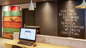 Un espacio de trabajo con una computadora, un escritorio y una pared que muestra varias palabras relacionadas con los negocios.